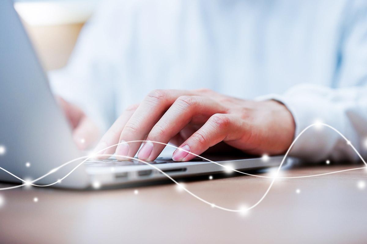 close up of hands working on laptop computer